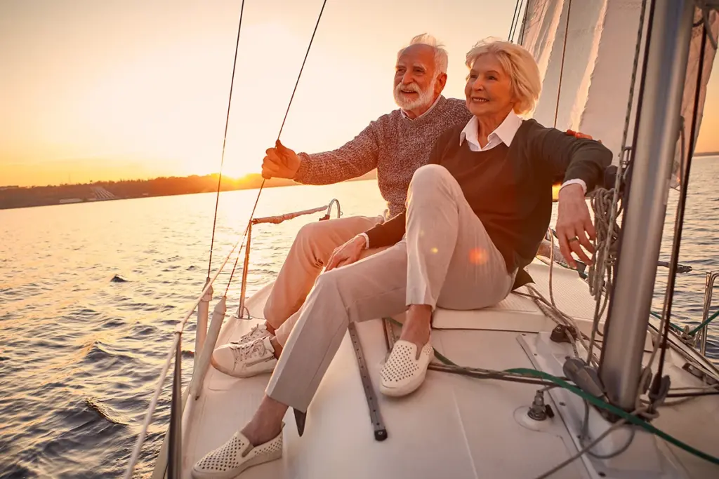 older couple smiling at sunset on sailboat