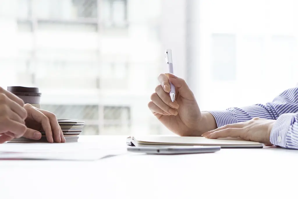 close up of woman with pen and documents